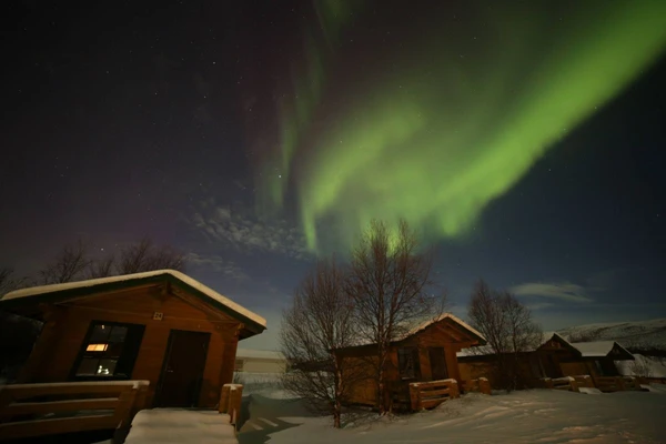 Magische Nordlichter über finnischen Hütten in der Natur