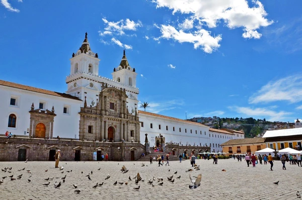 Belebter Platz in Quito, Ecuador mit historischer Architektur und Vögeln