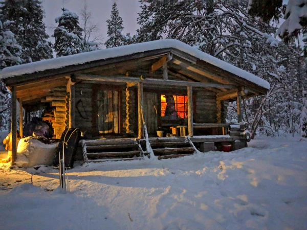 Urige finnische Wanderhütte in winterlicher Landschaft Finnlands