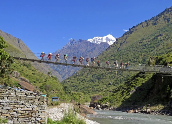 Wanderer überqueren Hängebrücke vor Shingri Himal in Nepal
