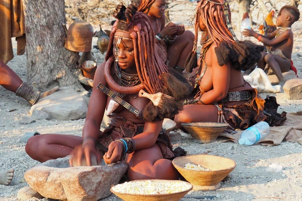Traditionelle Himbafrau aus Angola bei der Arbeit mit Körben