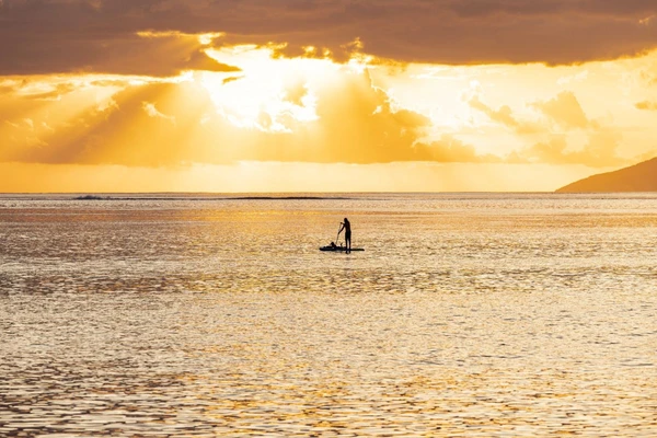 SUP vor der Küste Tahitis beim Sonnenuntergang in Französisch-Polynesien