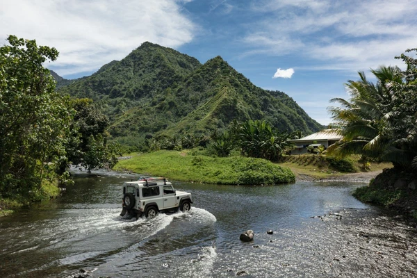Geländewagenfahrt durch einen Fluss in den Bergen von Tahiti